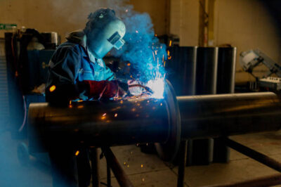 Industrial worker welding on the pipe